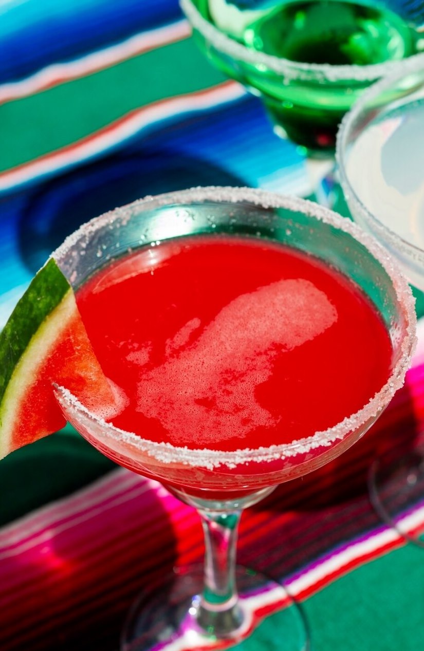 Watermelon margarita with a salted rim on colorful fabric